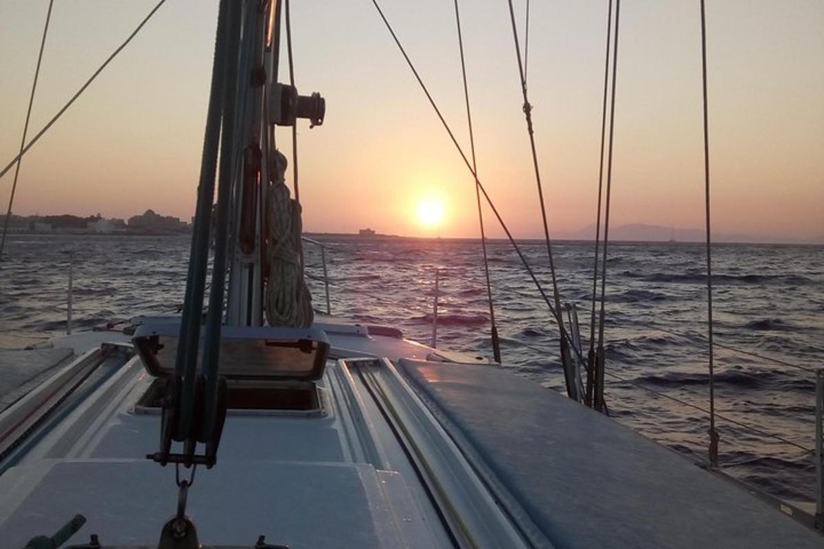 a boat in the ocean with the sunset in the background