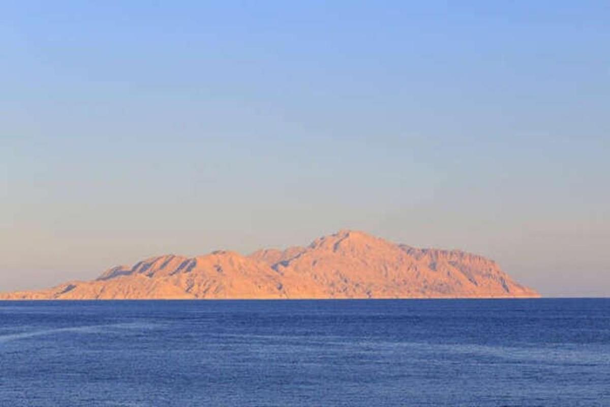 a mountain in the middle of a large body of water