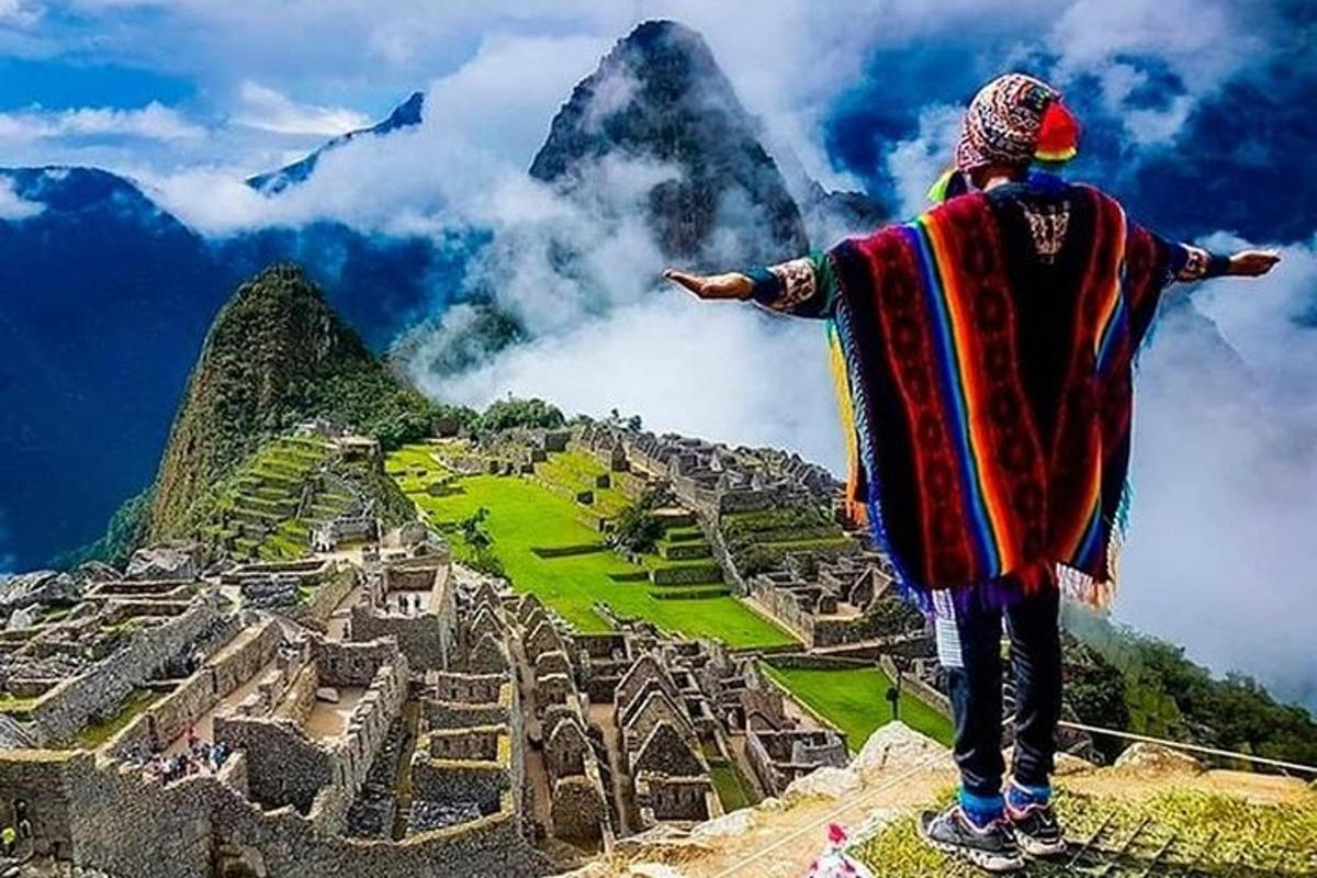Un hombre parado en la cima de una montaña mirando una ciudad.
