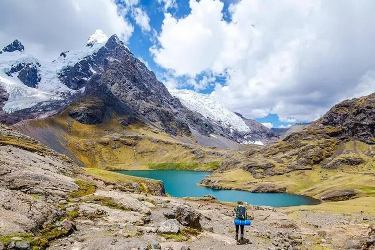 un uomo in piedi su una montagna che guarda un lago