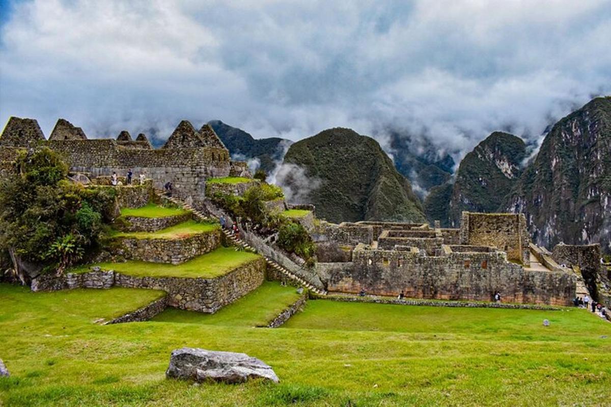 un vecchio edificio su un campo con le montagne sullo sfondo