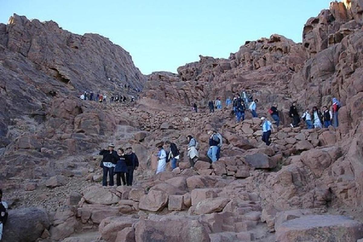 un grup de persones caminant sobre les roques d'una muntanya
