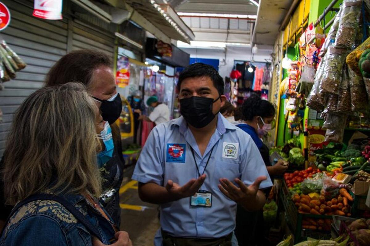 un gruppo di persone in un mercato che indossano maschere