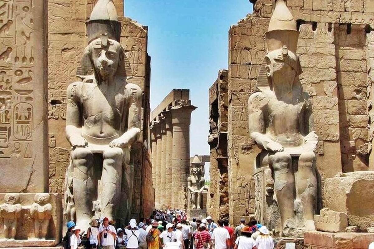 un gruppo di persone in piedi davanti a due statue