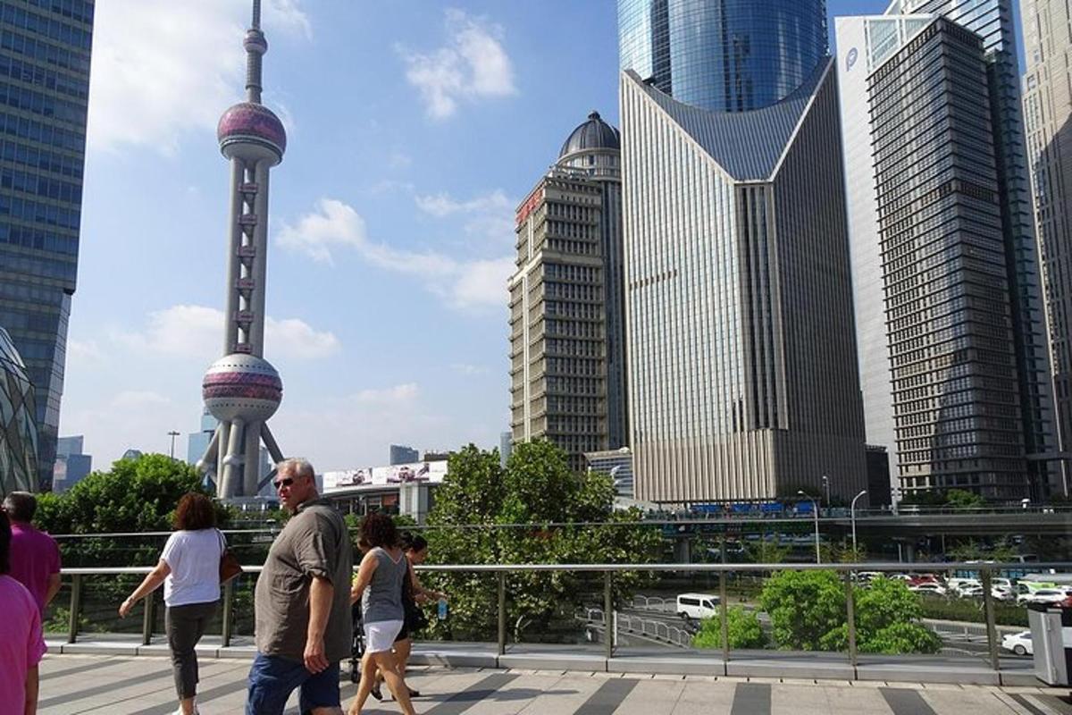 a group of people walking in a city with tall buildings