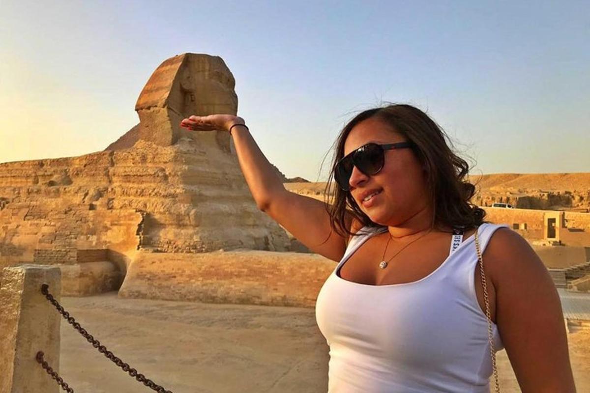 en kvinne med solbriller som står foran en pyramide