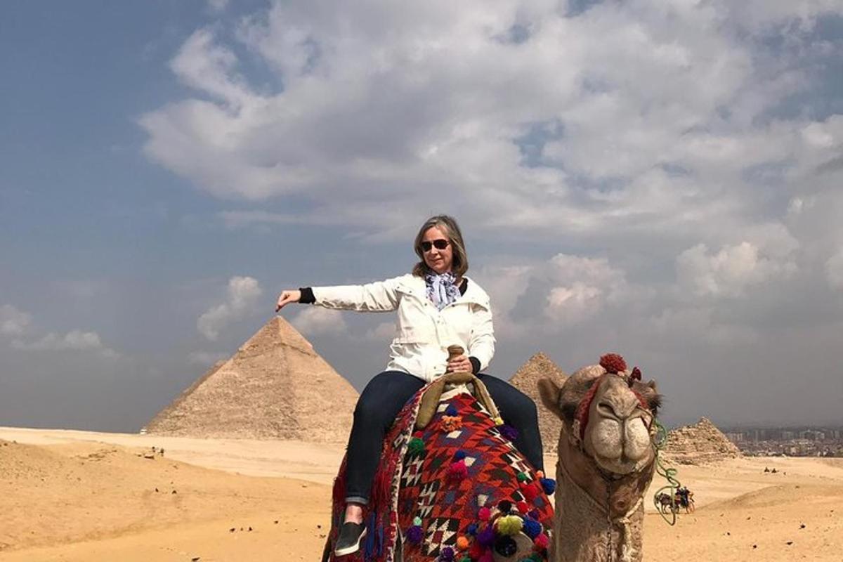 en kvinne som rir på en elefant foran pyramidene