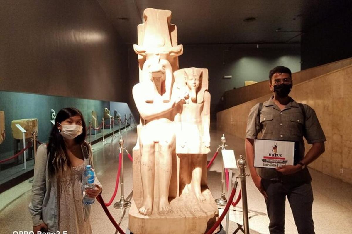 a man and a woman standing next to a statue