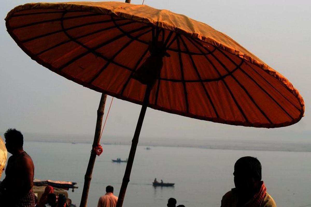 a person standing under an umbrella on a beach