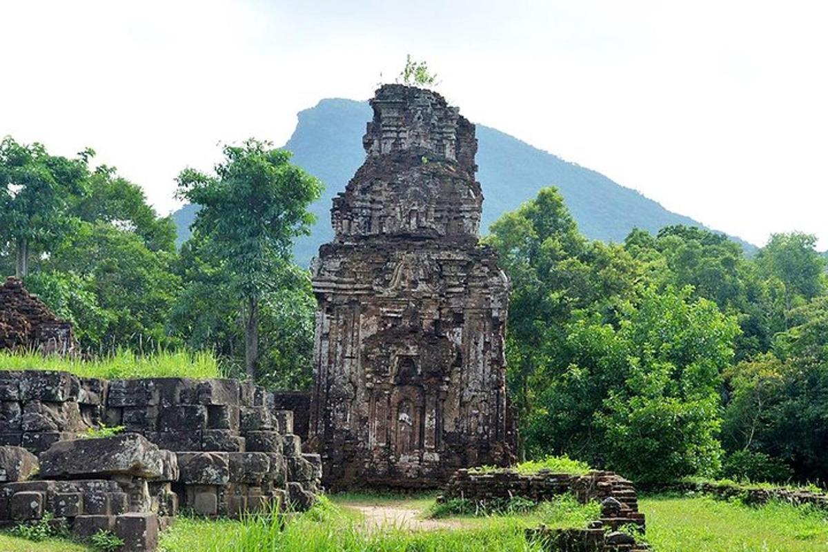 Un edificio antiguo en un campo con una montaña al fondo.