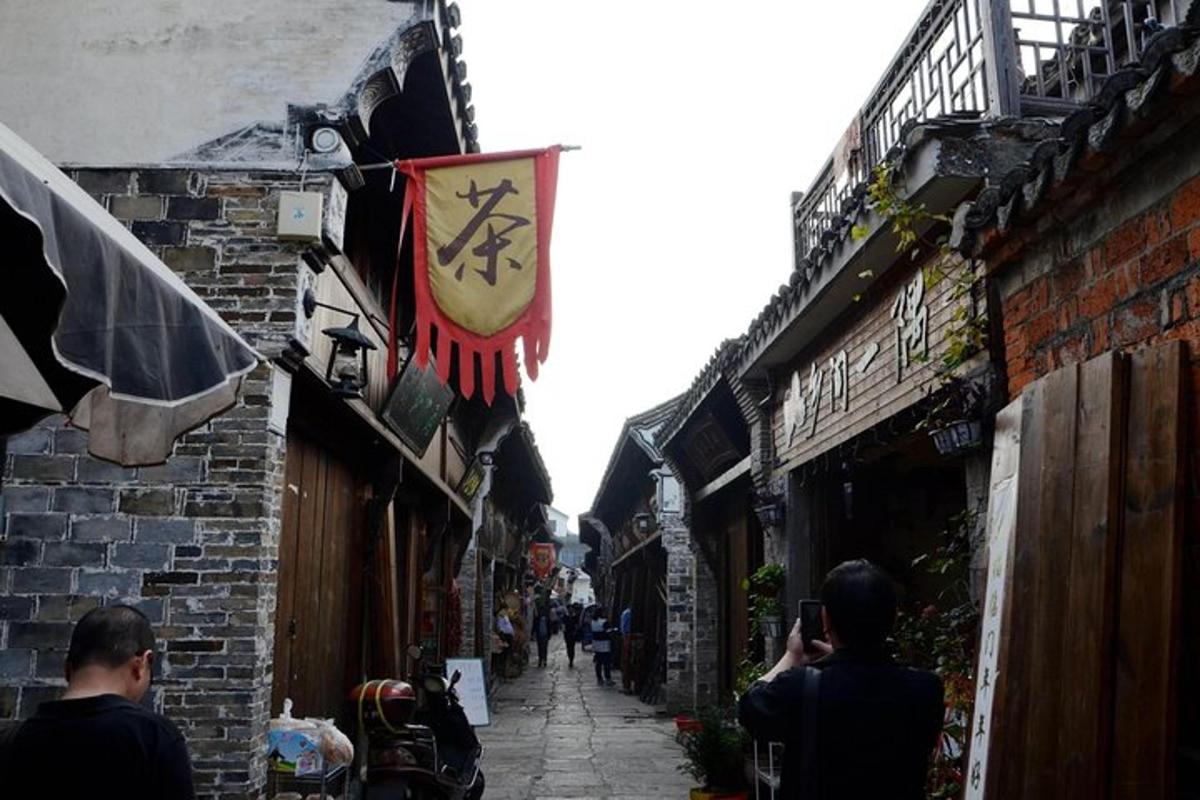 a group of people walking down an alley with a flag