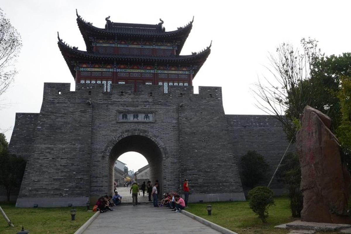 a gate to a castle with people sitting in front of it