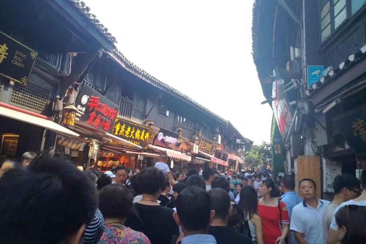 a crowd of people walking down a crowded street