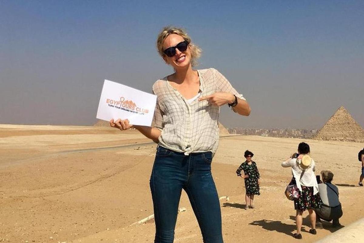 žena držící ceduli před pyramidami