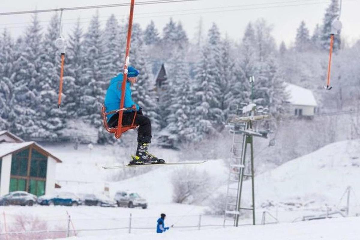 una persona con gli sci che salta da uno skilift