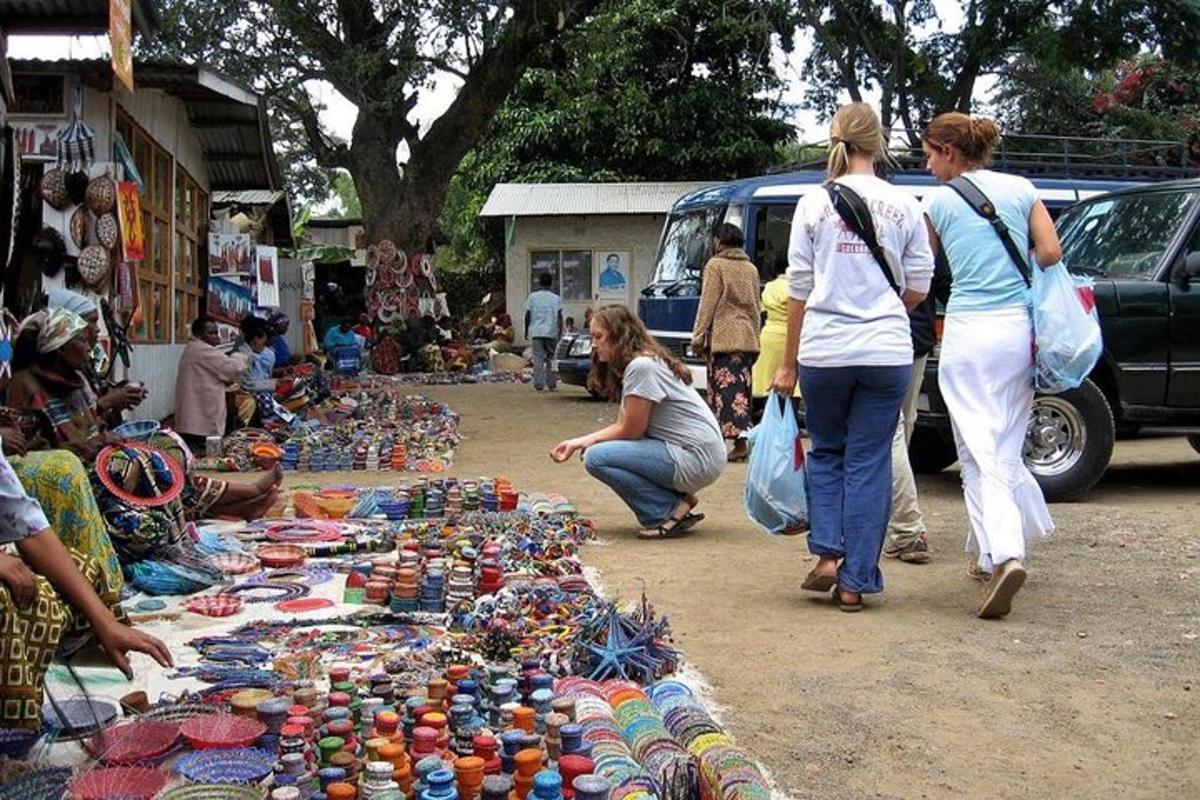 un gruppo di persone che camminano in un mercato con la merce