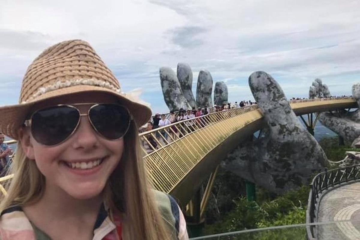 a woman wearing a hat and sunglasses on a roller coaster
