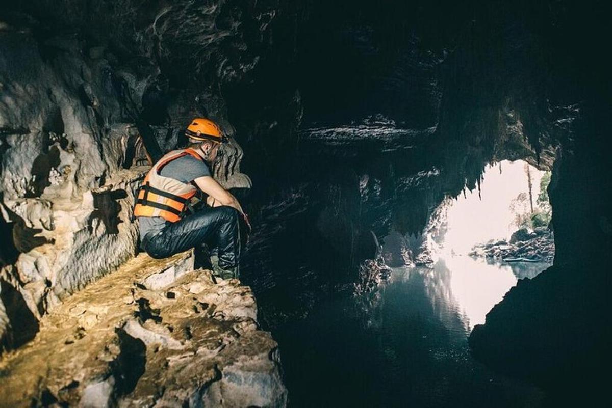 a man sitting on a rock in a cave