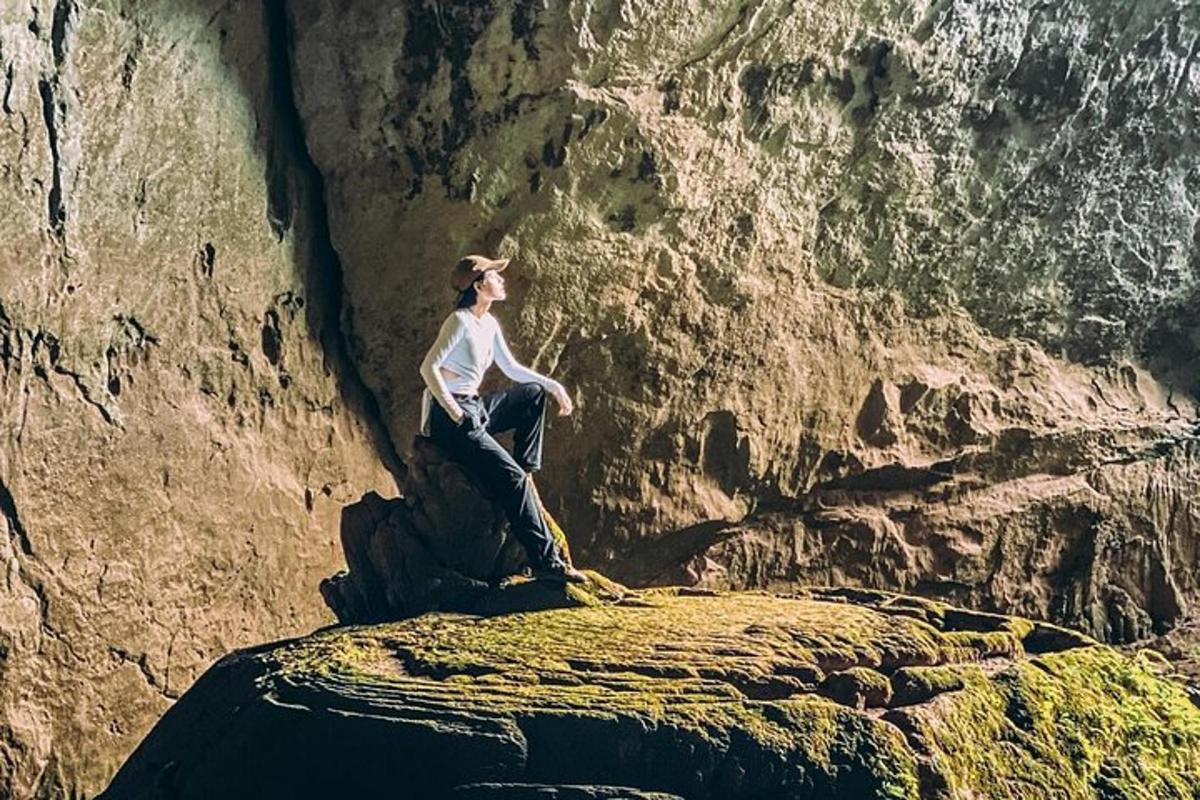 a woman sitting on a rock in front of a mountain