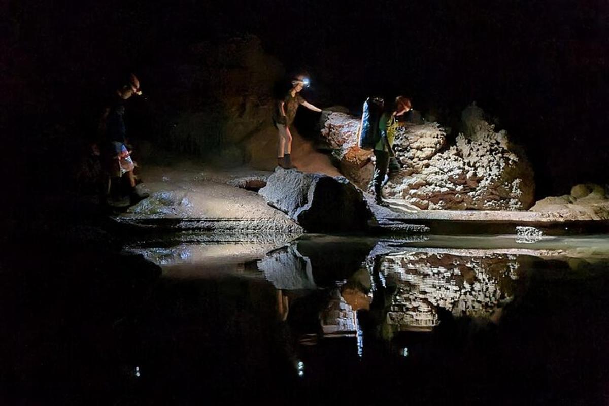 Un grupo de personas paradas sobre rocas cerca de un cuerpo de agua.