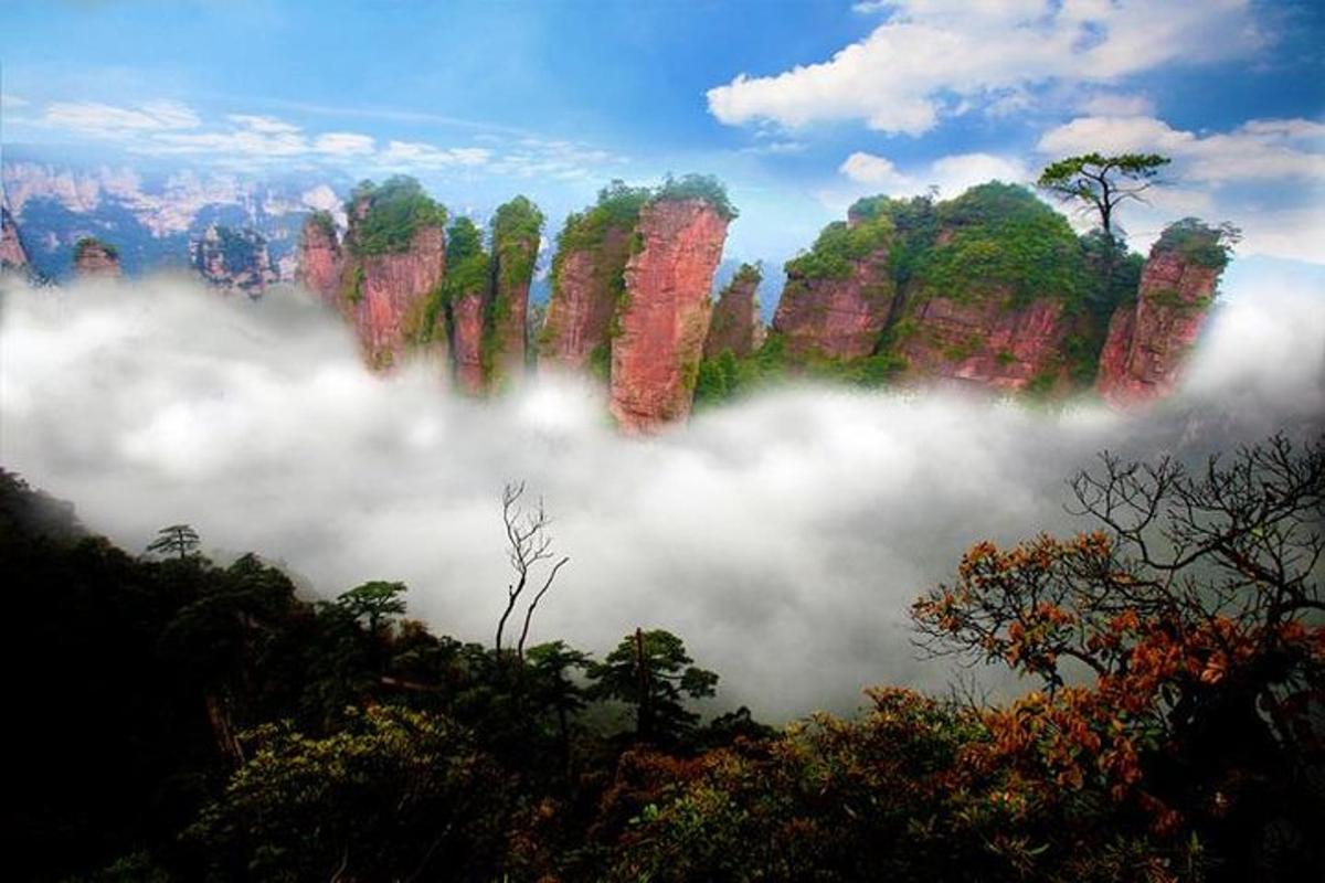 a view of a mountain range with clouds and trees