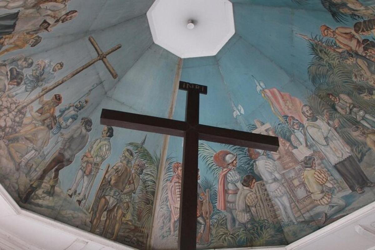 uma cruz no teto de uma igreja com um mural