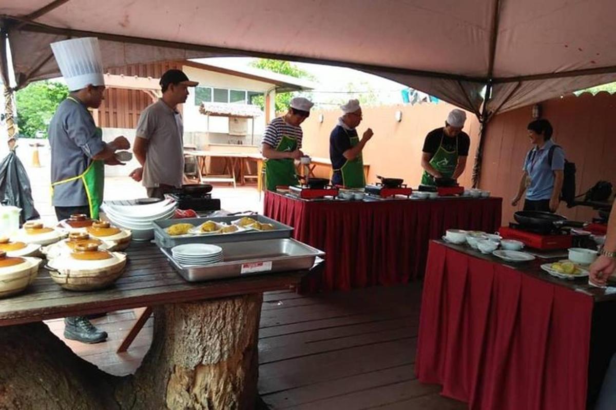 un gruppo di chef in piedi attorno a un tavolo con del cibo