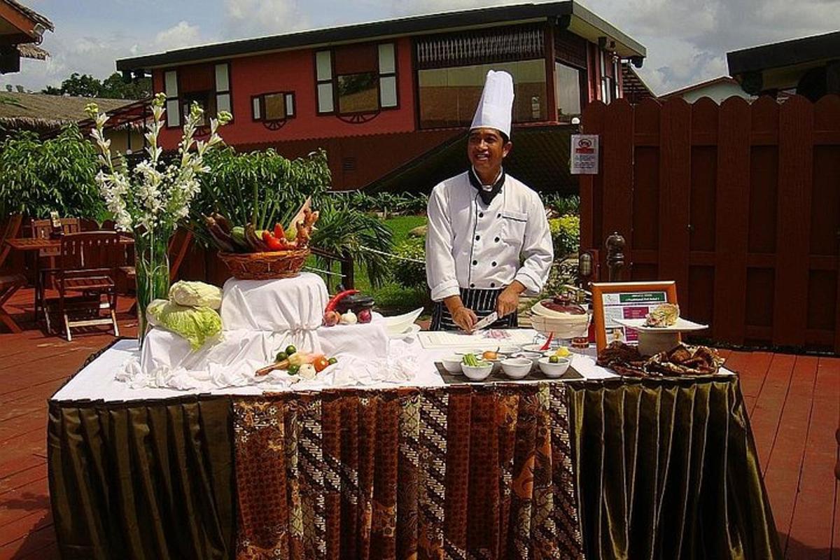 uno chef in piedi accanto a un tavolo con del cibo sopra