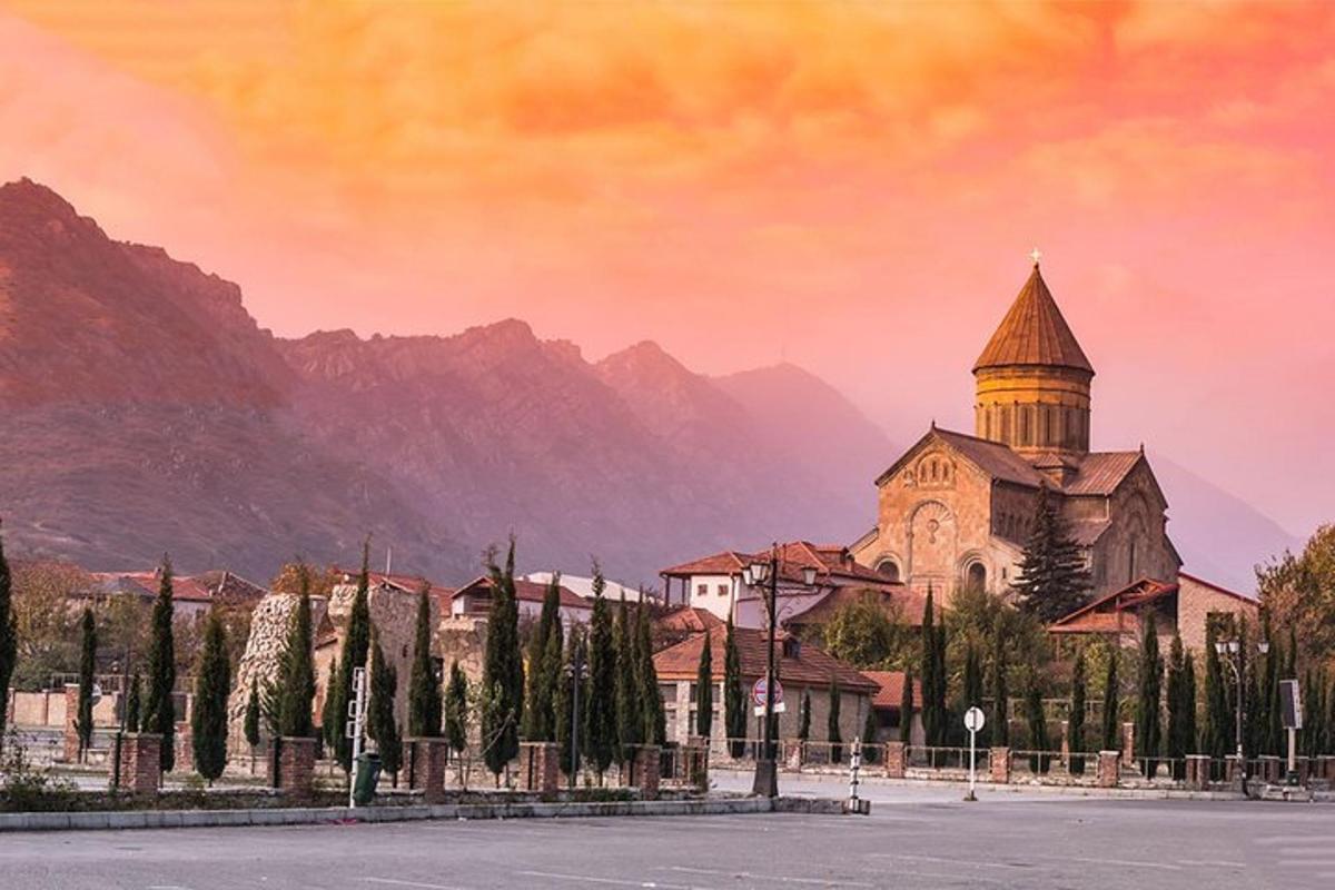 una església amb una torre davant d'una muntanya