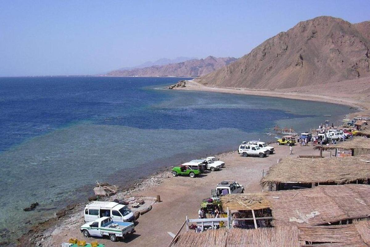 un gruppo di veicoli parcheggiati su una spiaggia vicino all'acqua