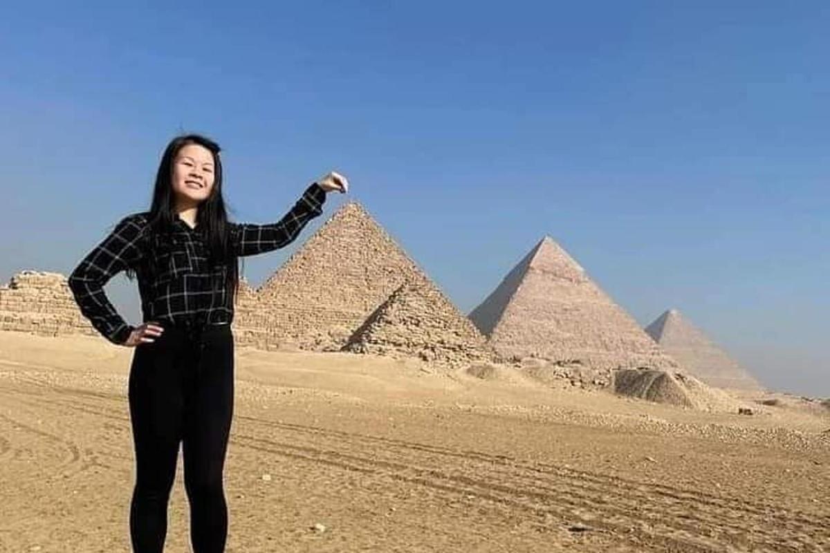 naine seisab püramiidide ees