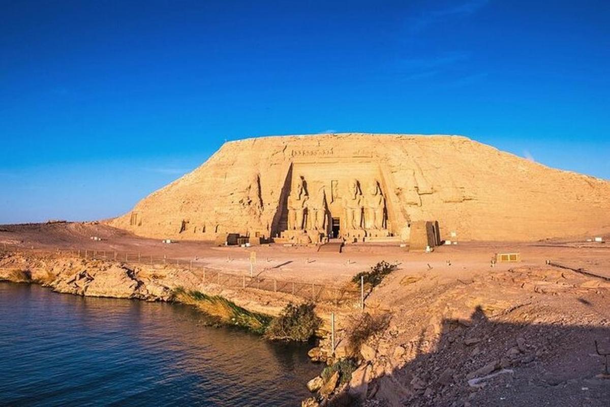uma colina de areia com uma igreja em frente à água