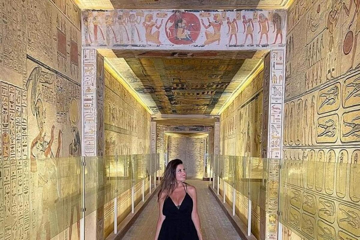 Una mujer con un vestido negro caminando por un túnel con pinturas.