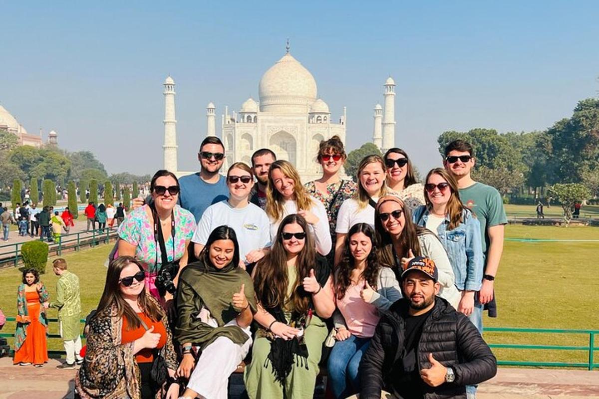a group of people posing for a picture in front of the taj mahal
