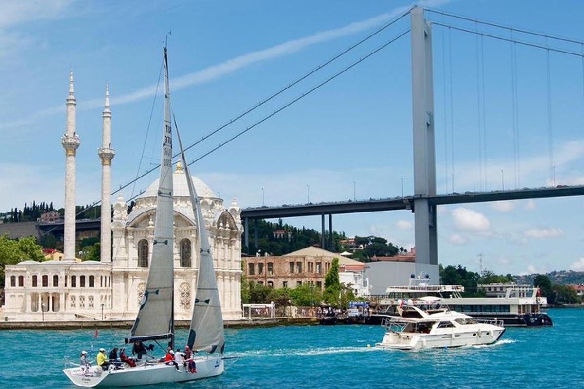 ein Segelboot im Wasser neben einer Brücke