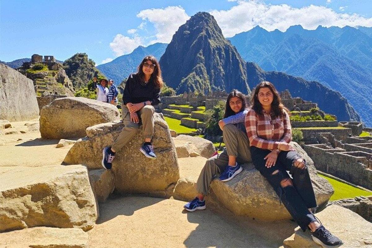 drie vrouwen zitten op rotsen op de top van een berg