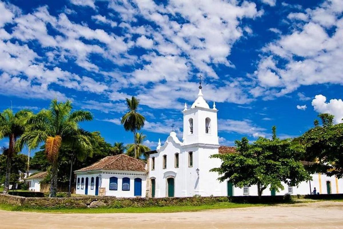 una iglesia blanca con palmeras y un cielo azul
