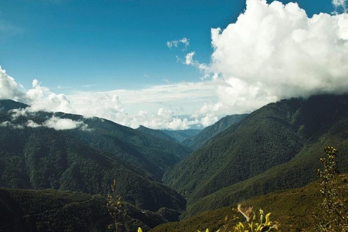 uma vista de um vale montanhoso com nuvens no céu