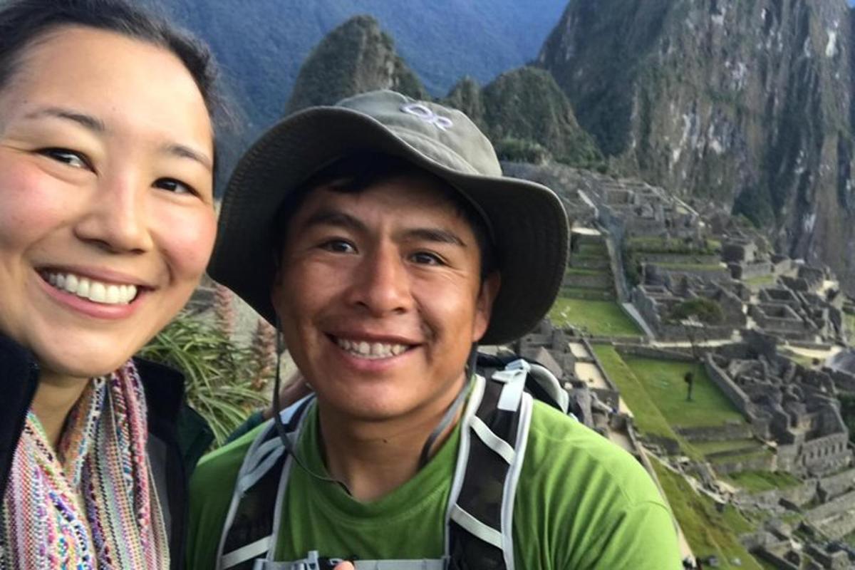 seorang lelaki dan seorang wanita berdiri di hadapan pemandangan gunung