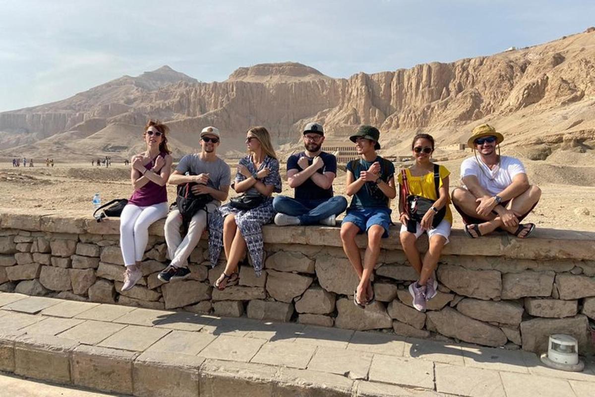 a group of people sitting on a wall in the desert