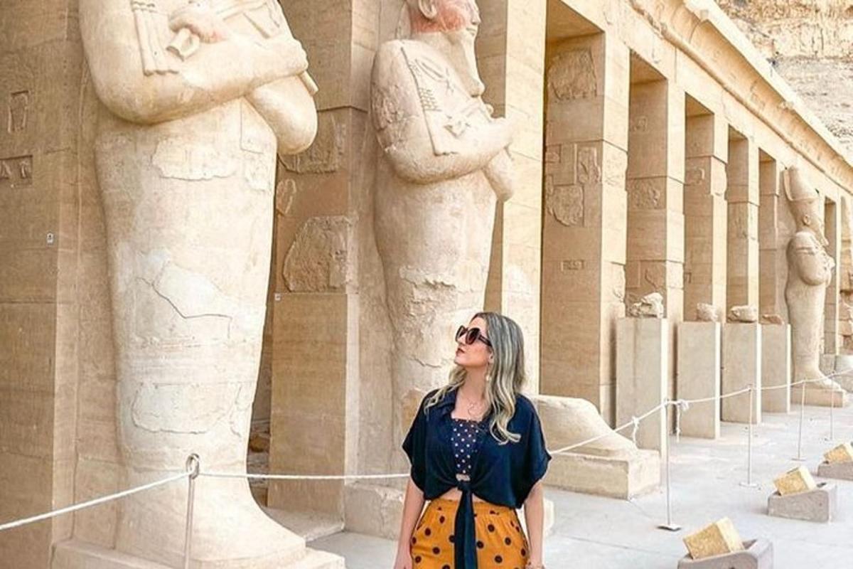 a woman is standing in front of a statue