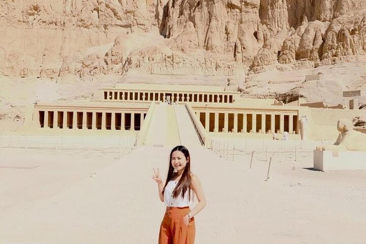a woman standing in front of a building in the desert