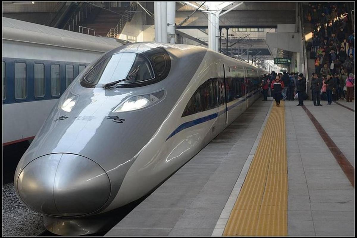 un treno in una stazione ferroviaria con persone sulla banchina