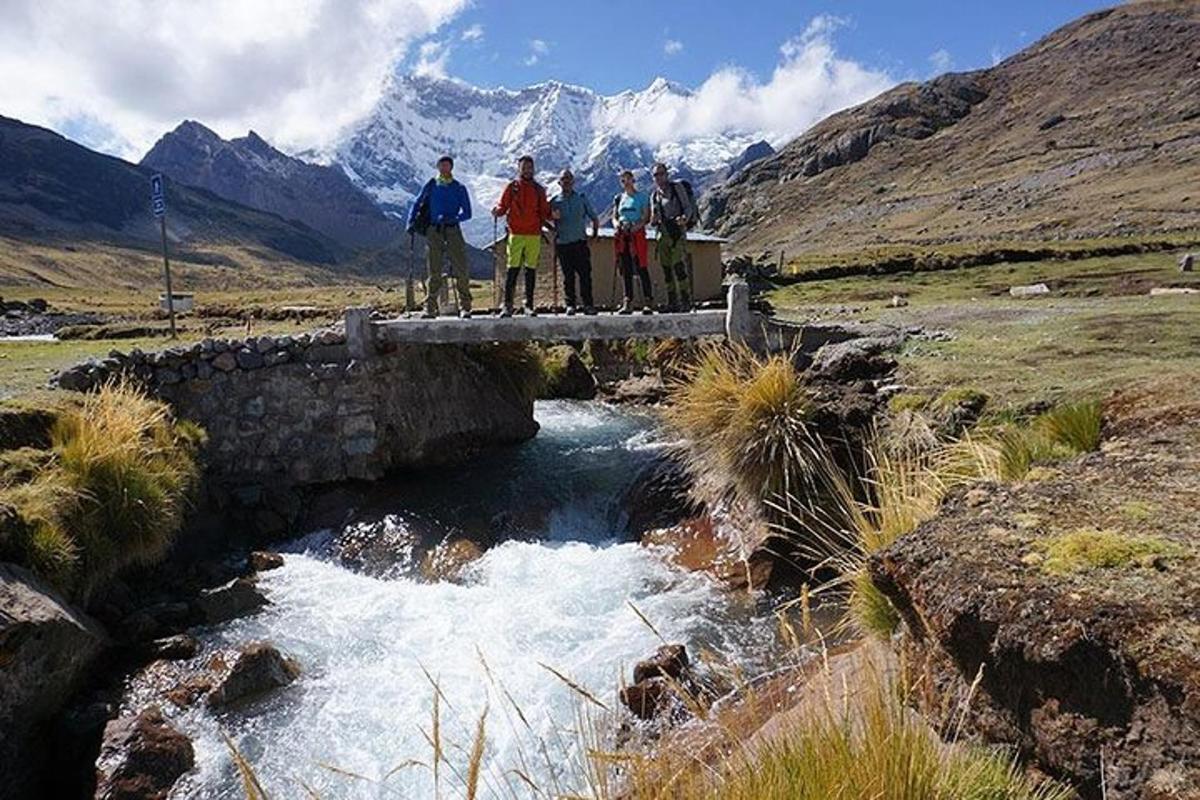Un grupo de personas de pie en un puente sobre un río.