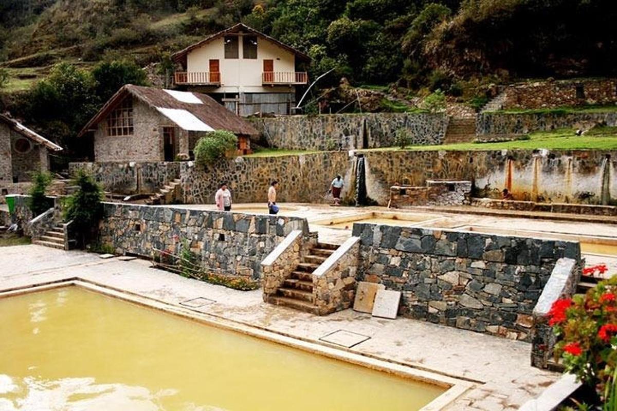 duas pessoas em pé ao lado de uma piscina de água