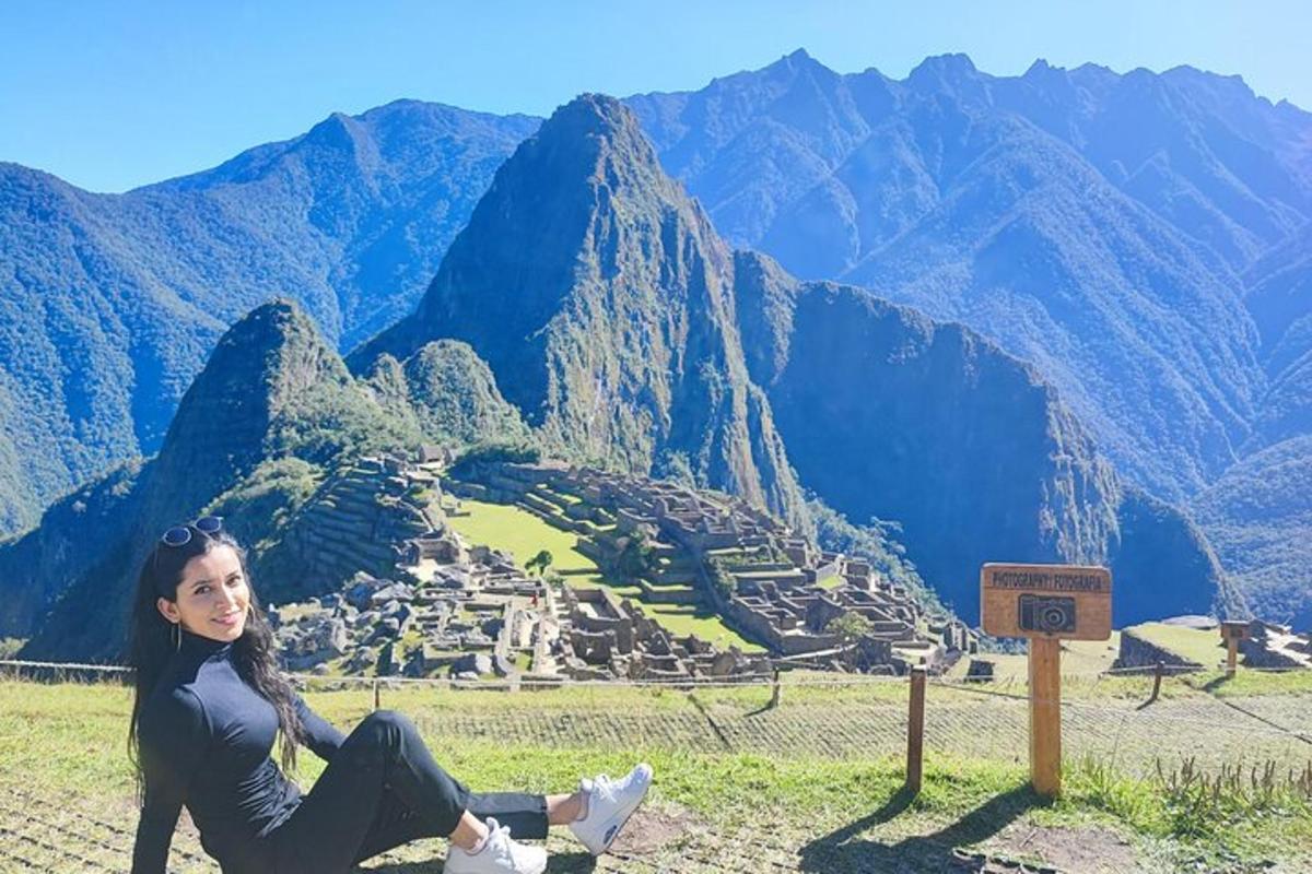 una donna seduta su una collina con vista su una città