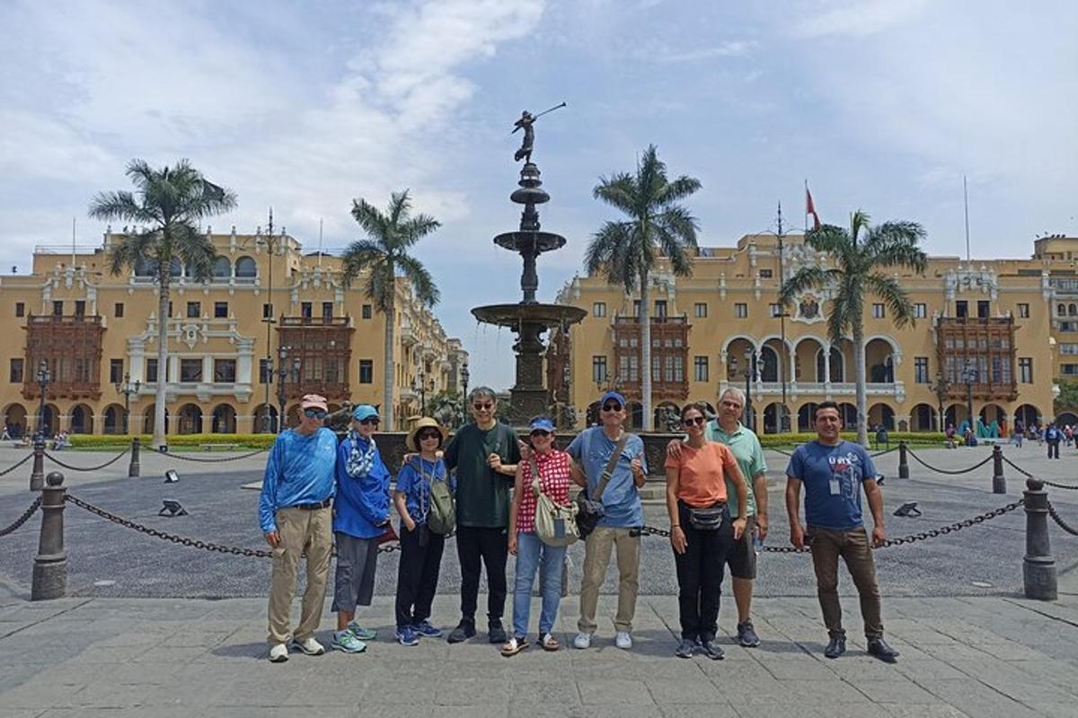 um grupo de pessoas em pé em frente a uma fonte