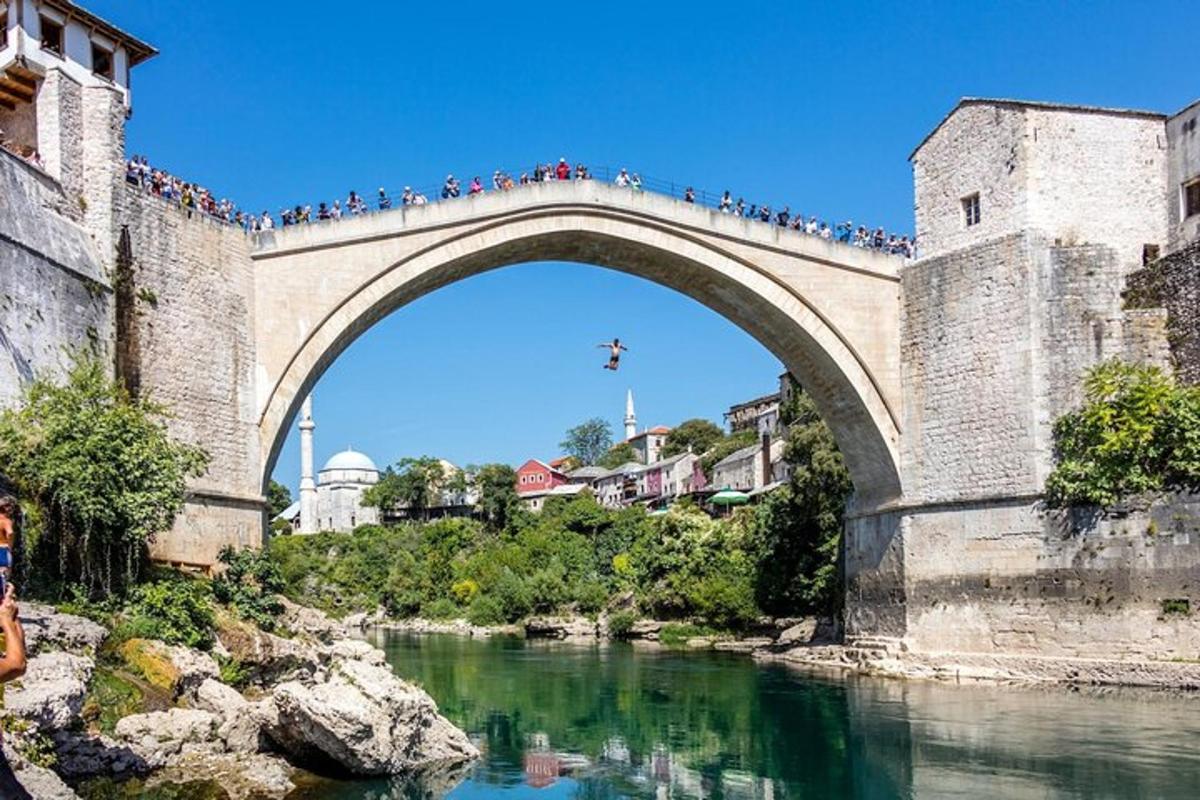 un grup de persones creuant un pont sobre un riu
