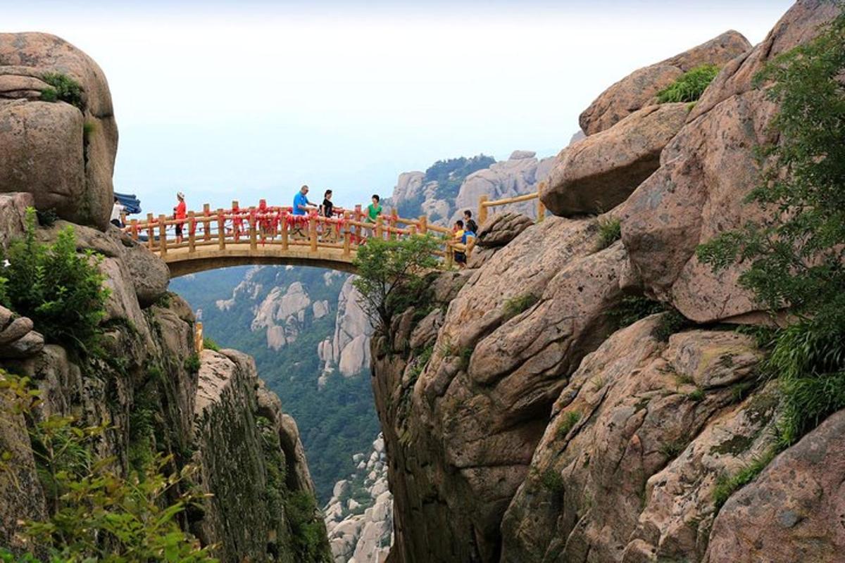 Un grupo de personas caminando sobre un puente en una montaña.