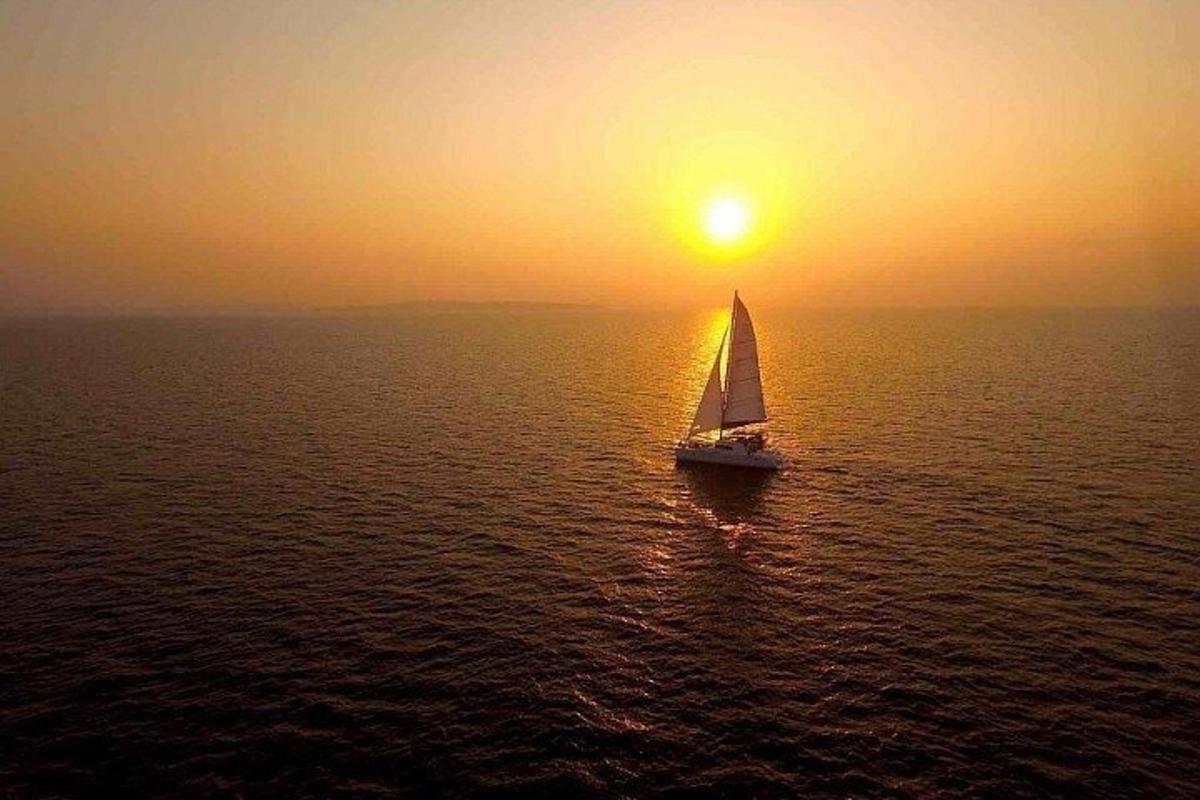 un velero en el océano al atardecer